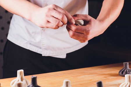 National Georgian cuisine Khinkali metal background Cook prepares khinkali kitchen Top view raw meat dough dish uncooked food booth selling Chinese specialty Steamed Dumplings Process cooking.の写真素材