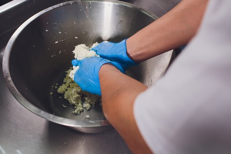 Traditional Cheese Making In A Small Company. Cheese Maker Hands Close-up Top View.の写真素材