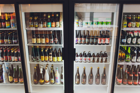 UFA, RUSSIA 5, 2018: Various bottles of craft, microbrew, IPA, domestic and imported beers from around the world on shelf display in supermarket cooler. Alcohol drink background. Panorama style.のeditorial素材