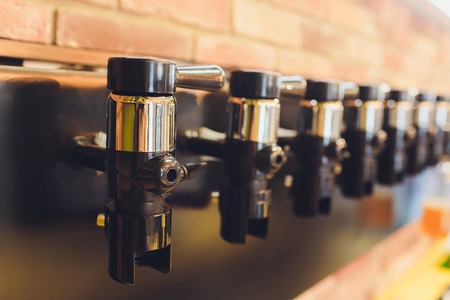 A row of nickel-plated beer taps at the bottling store.の写真素材
