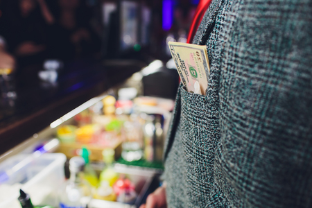 Bundle of dollars in your jacket pocket. Money in your jacket pocket. bribe in dollars. dollars twisted in a pack. businessman with a bribe. government corruption.の写真素材