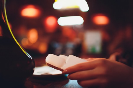 heat-not-burn tobacco product technology. woman holding e-cigarette in his hand before smoking.の写真素材