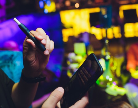 heat-not-burn tobacco product technology. Man holding e-cigarette in his hand before smoking.
