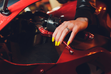 Woman's hand holding steering wheel motorcycle yellow manicureの写真素材