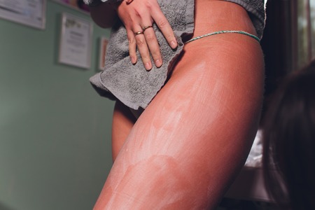 Body care. Woman applying cream on legs and buttocks. Female applying cosmetic cream from cellulite.の写真素材
