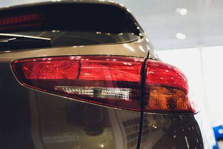 Close up of rear lights detail of modern luxury car with projector lens for low and high beam. Front view of sport crossover vehicle head lamp. Concept of car detailing and light technology backgroundの写真素材
