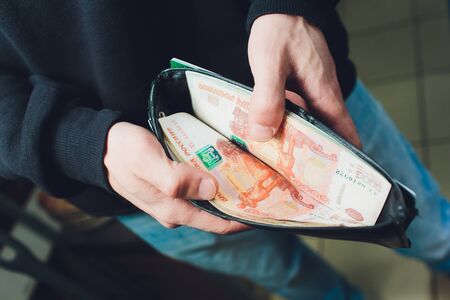 Hands take out russian rubles from wallet. Closeup on a mans hands as he is getting a banknote out...