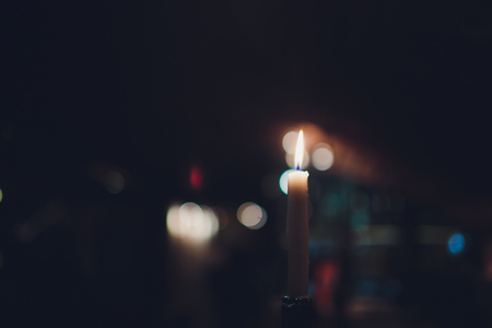Candles Burning at Night. White Candles Burning in the Dark with focus on single candle in foregroundの写真素材