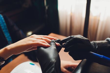 Master applying polish on fingernails on woman.の写真素材
