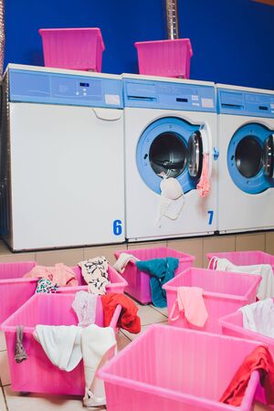 woman taking color clothes from washing machine.