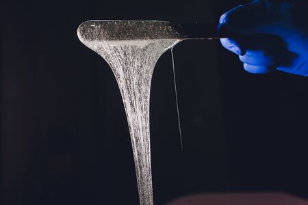 depilation and beauty concept - sugar paste or wax honey for hair removing with wooden waxing spatula sticks.の写真素材