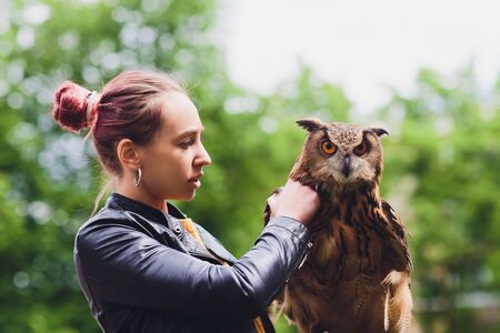 The owl sits on the girls hand. The woman with the owl.の写真素材