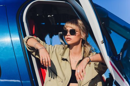 Female pilot in cockpit of helicopter before take off. Young woman helicopter pilot.