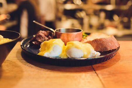 Traditional Caesar salad with chicken breast, tomatoes, lettuce, egg, parmesan and croutons in a black plate, isolated on a black background. Close-up. Space.の写真素材