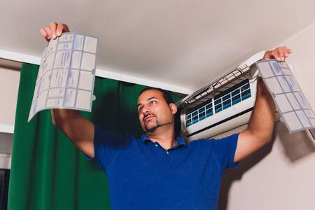 Male technician cleaning air conditioner indoors. serviceの写真素材