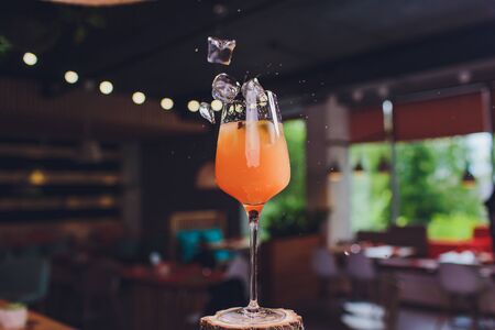 ice cubes falling into a splashing orange cocktail.の写真素材