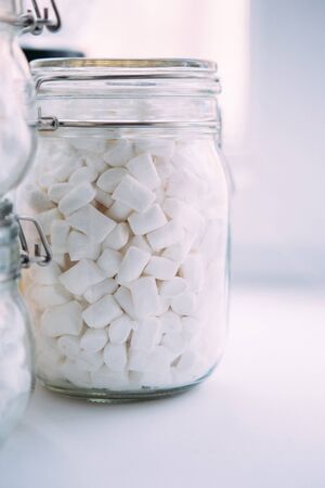 Beautiful white marshmallow in a glass jar. Marshemellou in a glass jar on a white background.の写真素材