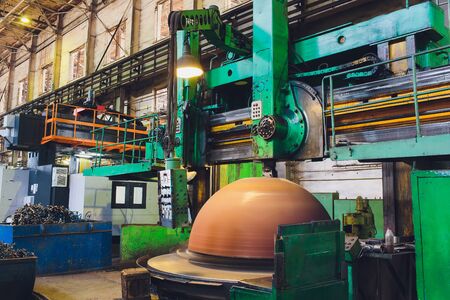 Workers in a foundry grind castings with a grinding machine - Heavy industry workplace.