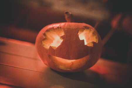 Halloween pumpkin lantern with dry leaves with black background.の写真素材
