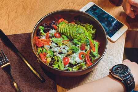 Vegetable salad with avocado, cucumber, cherry tomato, chard leaves and broccoli on a plate, on the...