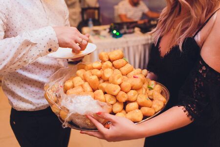 A hand holds a plate with sweet Asian chak-chak cake with honey.の写真素材