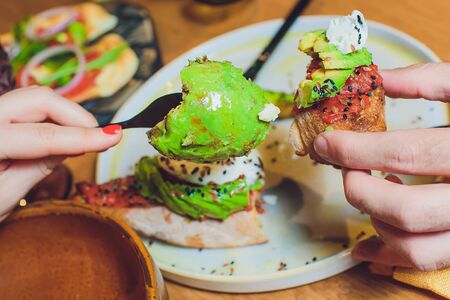 Whole grain bread sandwiches with fried quail egg, avocado, herbs and seeds on black background. Clean eating, healthy vegan breakfast.の写真素材