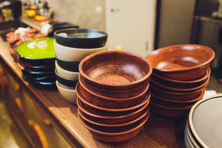 Vintage multicolored empty plates and bowls on a dark gray linen tablecloth with sunflower. With antique spoons and forks. Table setting. Shabby chic retro style. Top view. Rustic kitchen.の写真素材