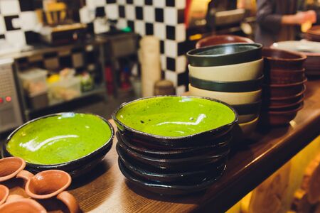 Vintage multicolored empty plates and bowls on a dark gray linen tablecloth with sunflower. With antique spoons and forks. Table setting. Shabby chic retro style. Top view. Rustic kitchen.の写真素材