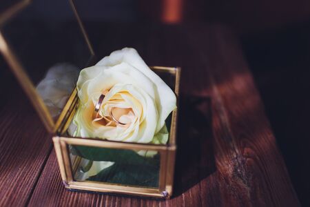 wedding rings in the box and a bouquet of the bride on the table.の写真素材