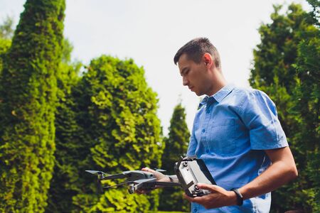 man and his drone, quadrocopter in a forest on a green background.