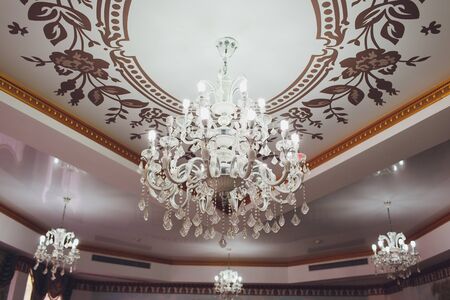 Chrystal chandelier lamp on the ceiling in Dining room Adjusting the image in a Luxury tone...