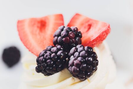 Dessert with berries on a meringue with cream.の写真素材