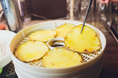 Fresh dryed apple chips prepared in a home fruit and vegetable dryer. Healthy food concept.の写真素材