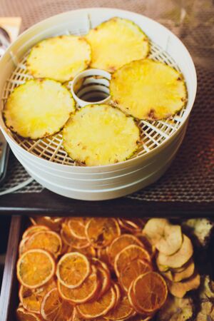 Fresh dryed apple chips prepared in a home fruit and vegetable dryer. Healthy food concept.の写真素材