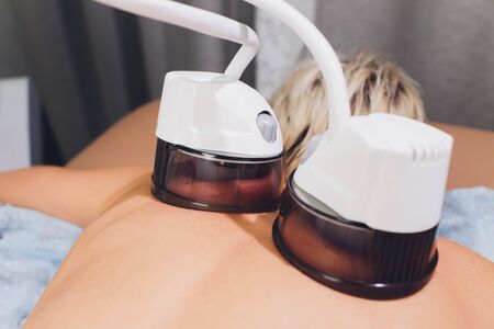 Cropped view of cosmetologist with roller doing buttocks starvac massage.の写真素材