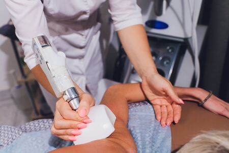 Cropped view of cosmetologist with roller doing buttocks starvac massage.の写真素材