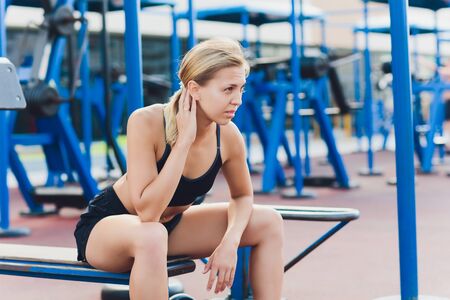 Profile view of a female athlete doing some tricep dips on a park bench.の写真素材