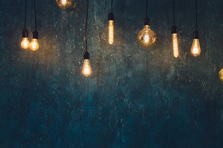 light bulb Edison filament retro vintage decor on brick wall background. Lighting decoration.