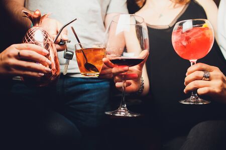 Clinking glasses with alcohol and toasting, party. Congratulations to the event. Cheerful party friends. man with a car key, sobriety conceptの写真素材