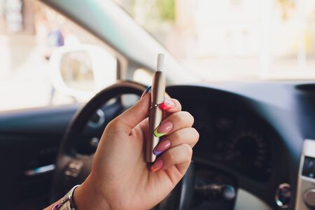 heat-not-burn tobacco product technology. e-cigarette before smoking in the car.の写真素材