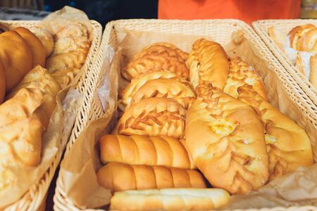Assortment of sweet pastries on the cafe counter, bread roll with poppy seeds, cinnamon and raisins.