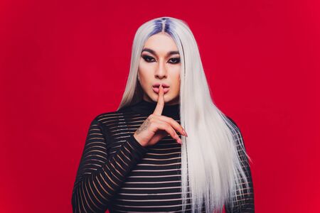 Portrait of young transgender woman on color background.