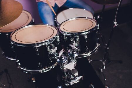 Young man behind drum-type installation in a professional recording studio.の写真素材