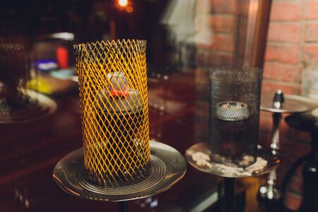 Shisha hookah with red hot coals. Sparks from breathe. Modern hookah with coconut charcoal and...