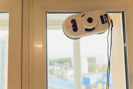 Vacuum cleaner robot cleaning window in high building outdoorの写真素材