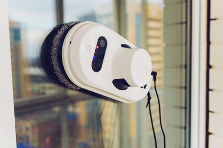 Vacuum cleaner robot cleaning window in high building outdoorの写真素材