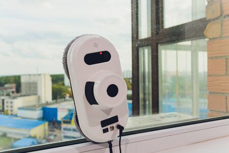 Vacuum cleaner robot cleaning window in high building outdoor