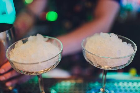 A bartender makes a cocktail over the marble bar counterの写真素材