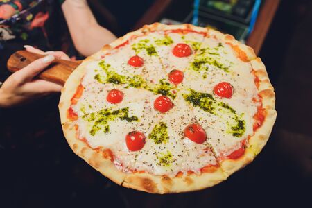 Young woman holding plate with tasty pizza, close up viewの写真素材