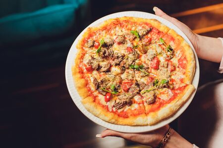 Young woman holding plate with tasty pizza, close up view.の写真素材